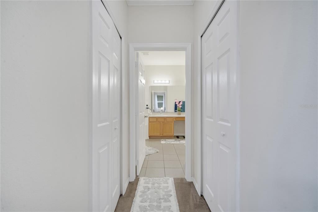 Master bath with walk-in closets on both sides