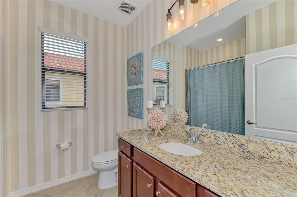 The guest bath has a tub/shower configuration and large vanity