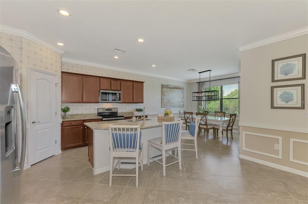 The kitchen island sits adjacent to the dining area, and has a walk in pantry