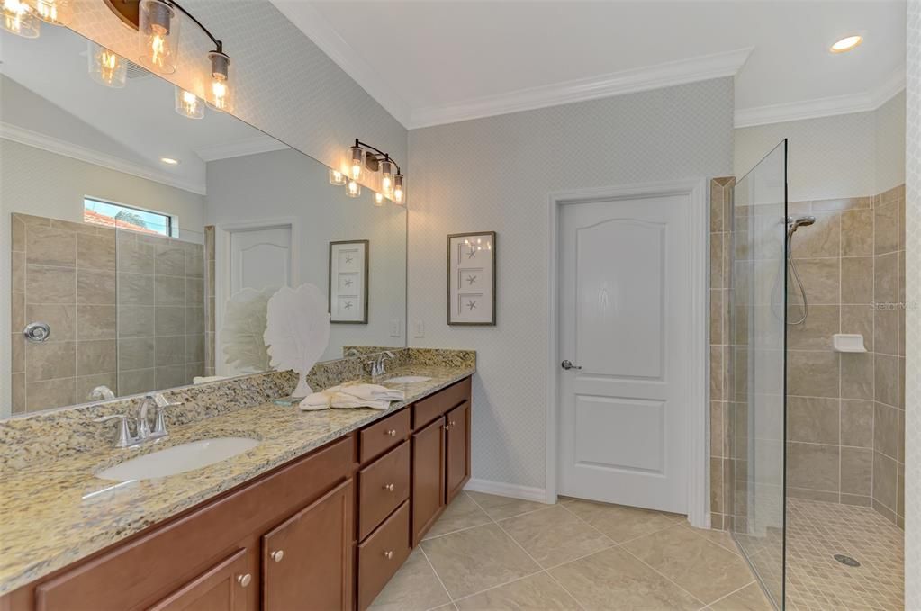 The ensuite has dual sinks, multiple cabinets, a water closet, and walk in shower, plus a large master closet.