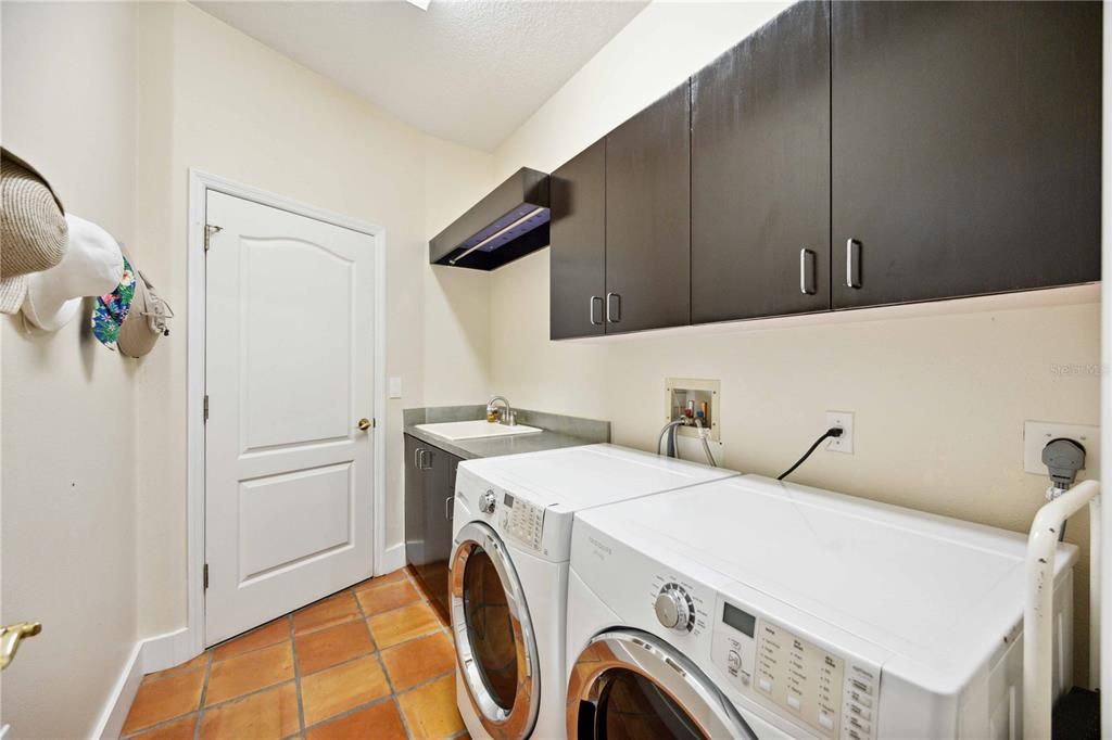 Laundry room inside by the kitchen with utility sink and closets for more storage