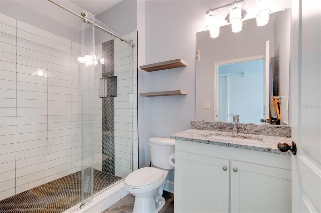 Primary Bath with Penny tile backsplashes, and timeless subway tile wainscoting features a premium shower system