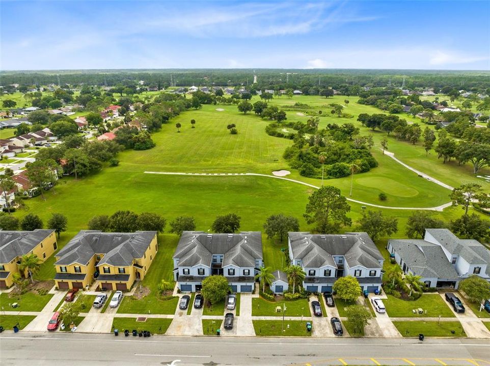 Aerial view of the front of the property and golf course in the background.