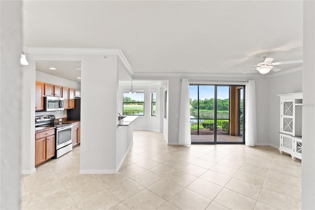 Left to Right: Kitchen and Living Room; Sliding Glass Door leads to Screened in Lanai and view of the hole/fairway