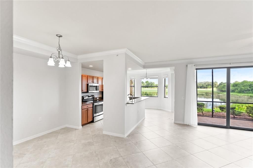 Left to Right: Dining Room, Kitchen and Living Room; Sliding Glass Door leads to Screened in Lanai and view of the hole/fairway