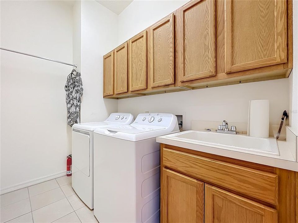 Laundry Room features a utility sink and plenty of cabinets