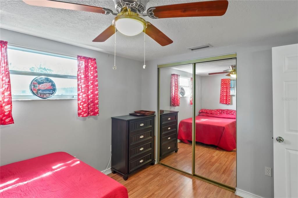 second bedroom with mirror closet doors, next to bathroom