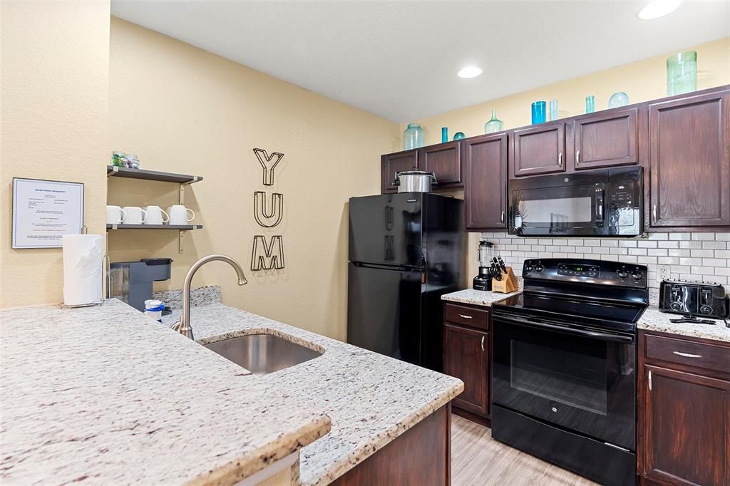 Kitchen offers granite countertops, upgraded appliances and backsplash