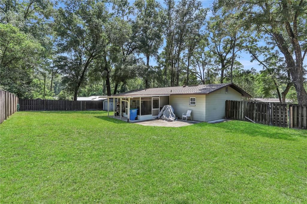 Spacious backyard with privacy fencing and a screened in porch