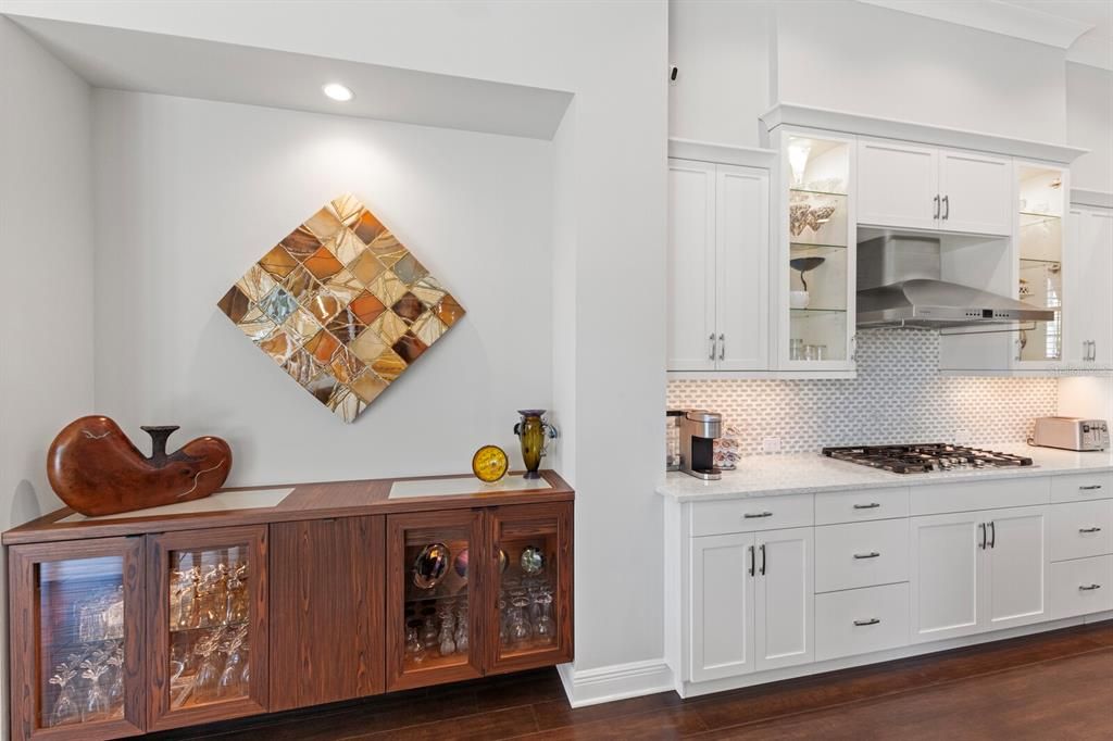 Built-in dry bar with a lit top and lighting for the display shelves. Pull out to store bottles.