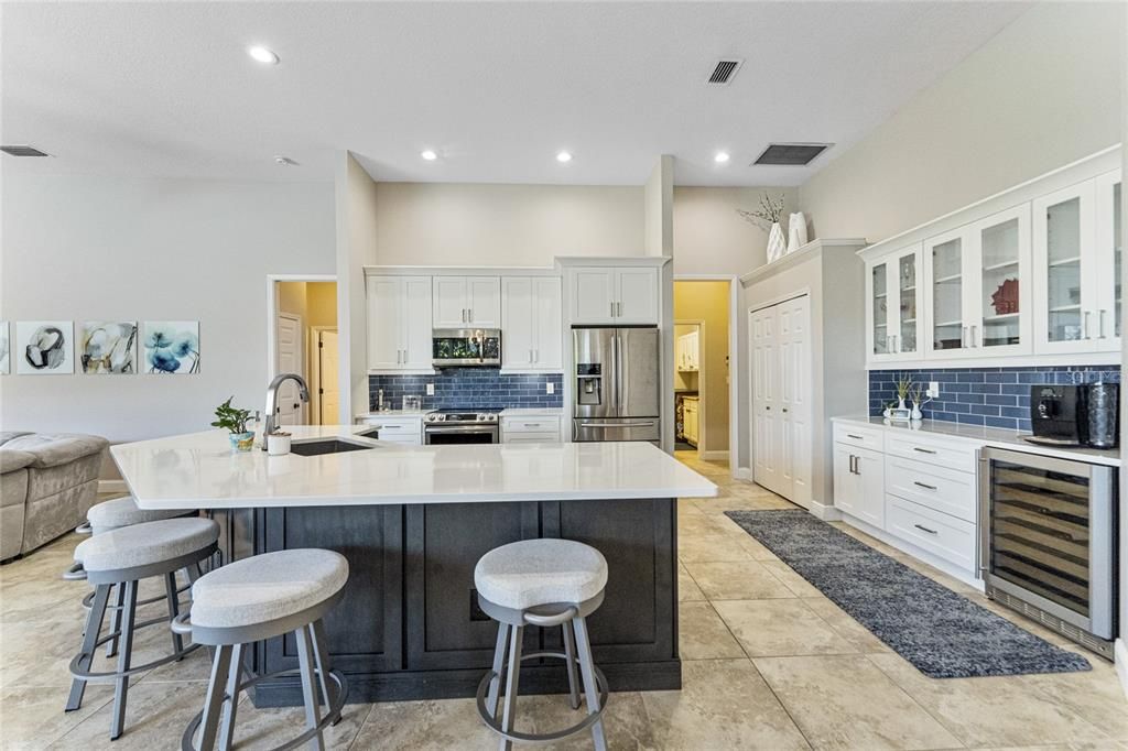 Remodeled kitchen with quartz counters, wine refrigerator and custom backsplash