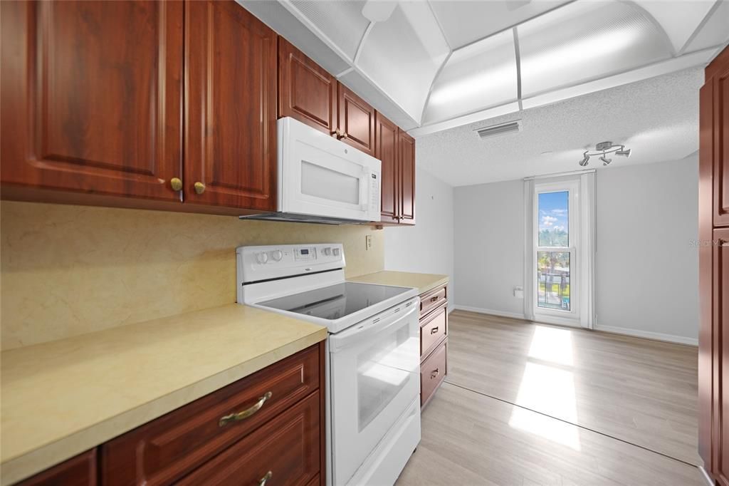 Kitchen View to Dining Area with Tennis Court/Pool Views