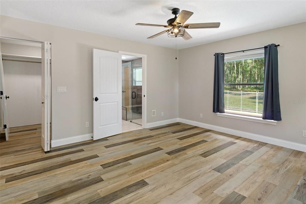 Walk-in closet and ensuite bath in primary bedroom.