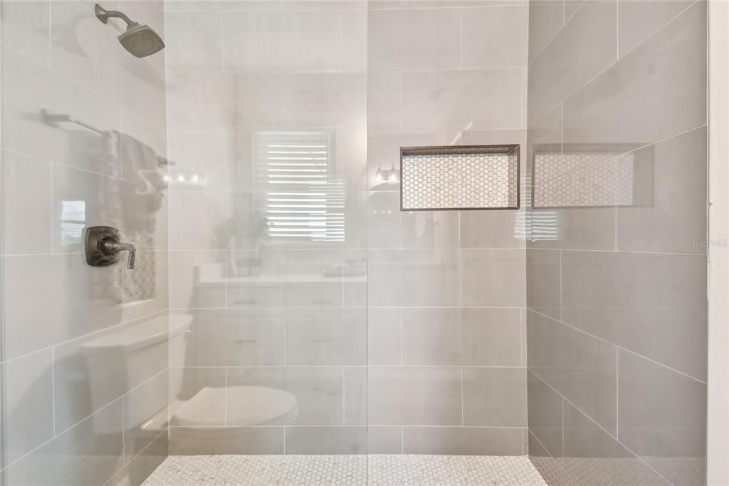 Elegantly tiled walk in shower with a niche for all your shower needs.