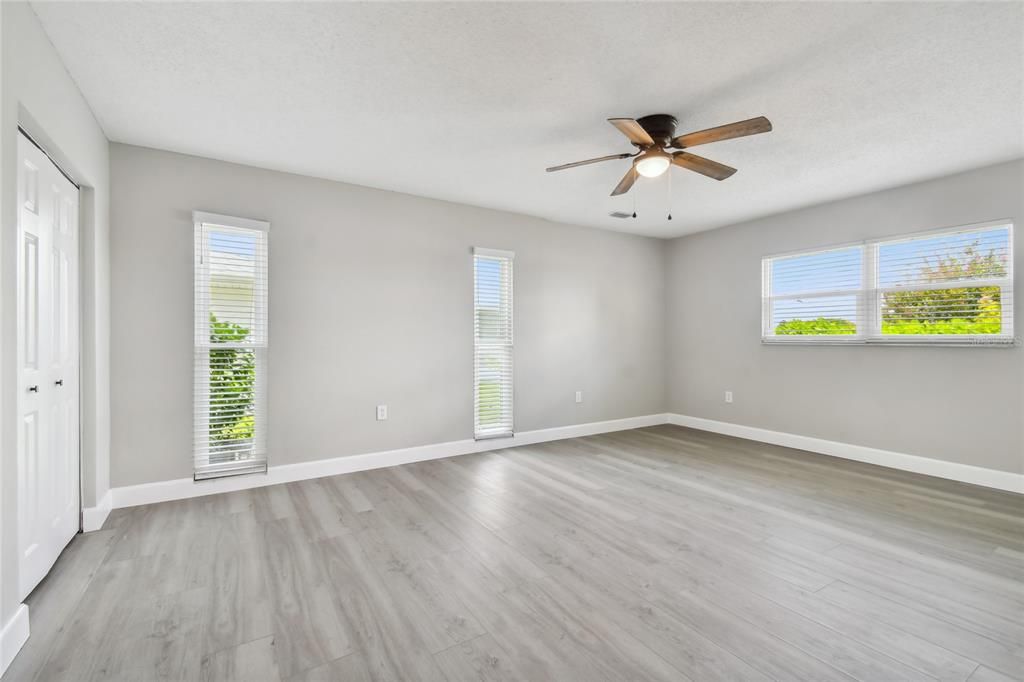 Primary bedroom boasts lots of windows to keep the room light and bright.