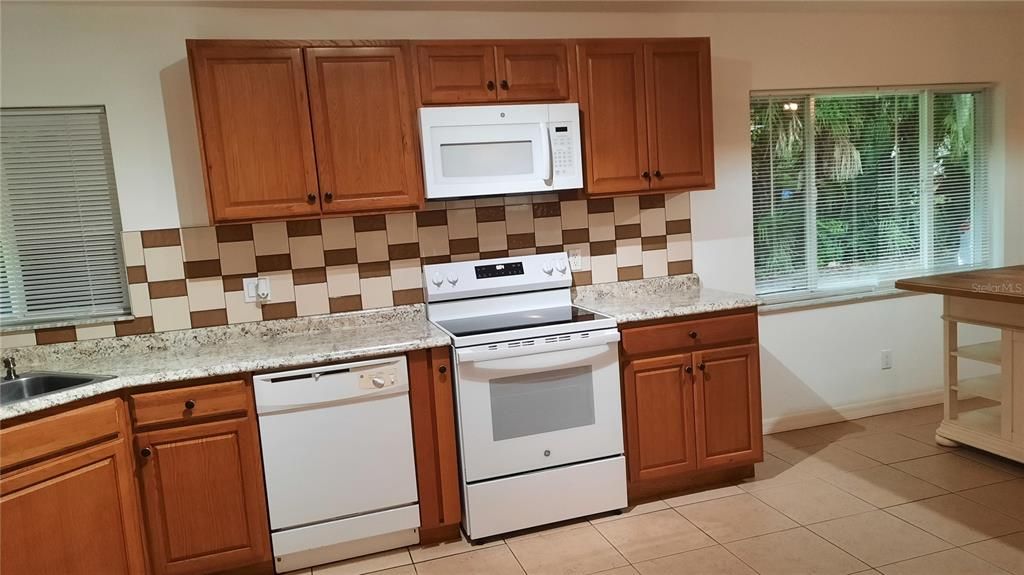 Spacious & bright kitchen with many cabinets and pantry