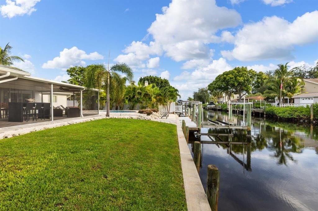 Back yard and canal with boat dock and lift.