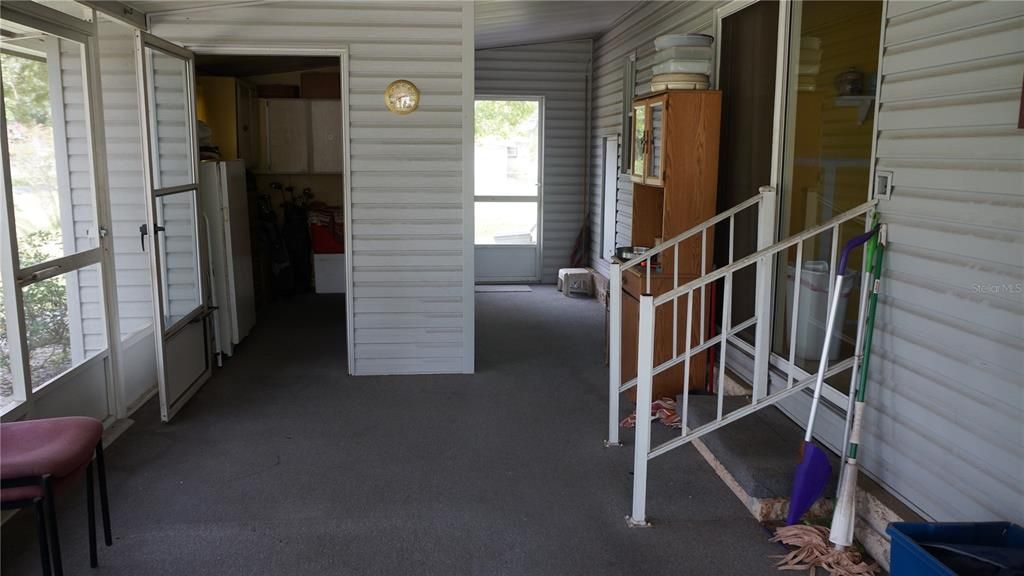 Side screened in porch with the laundry room and door into the fenced in back yard.