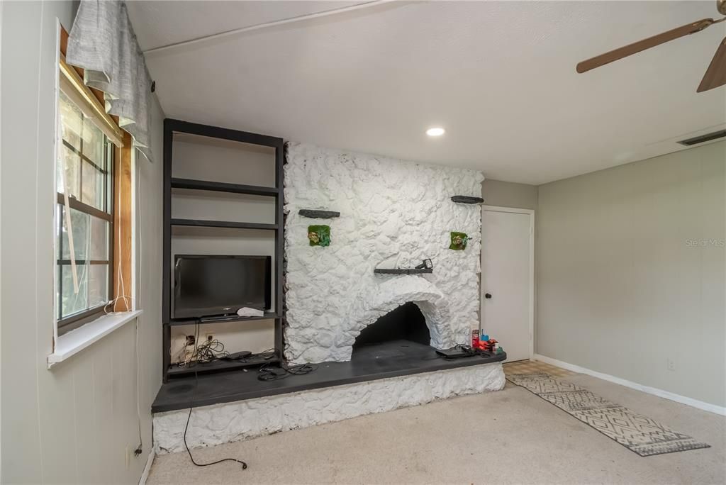 First floor living room with fireplace and entry from garage