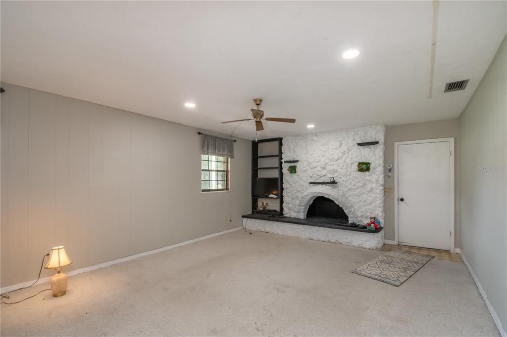 First floor living room with fireplace and entry from garage