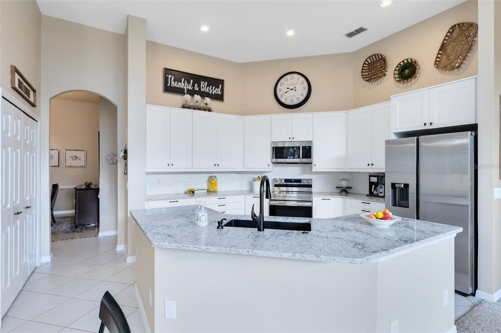 Gorgeous and spacious, the kitchen invites chef's and guests to fabulous meals. All new cabinetry, quartz countertops including a huge island, tile backsplash and newer updated appliances.