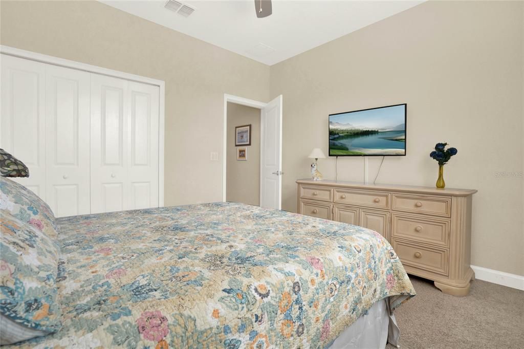 Bedroom 2 offers wall to wall carpeting and a ceiling fan