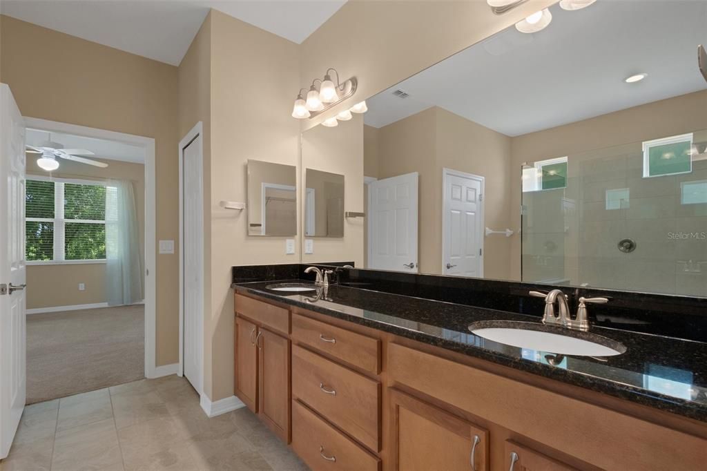 The vanity in the Owners bathroom is counter height, features dual sinks , solid wood cabinetry , linen closet and plenty of storage