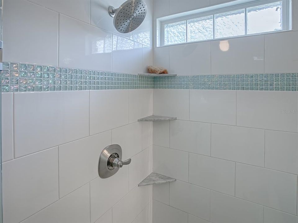 BEAUTIFUL TILING, A GLASS-BLOCK WINDOW AND BUILT-IN SHELVING IN THE WALK-IN SHOWER