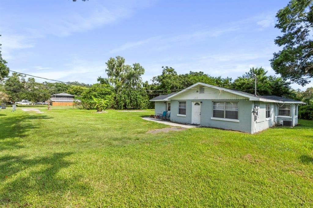 Front elevation and a view of the large fenced in lot that surrounds the home.