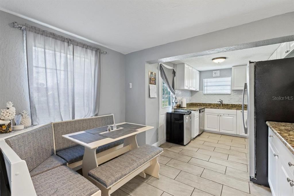 Galley-Style kitchen featuring granite countertops, ample cabinetry, stainless steel appliances, and a dinette.