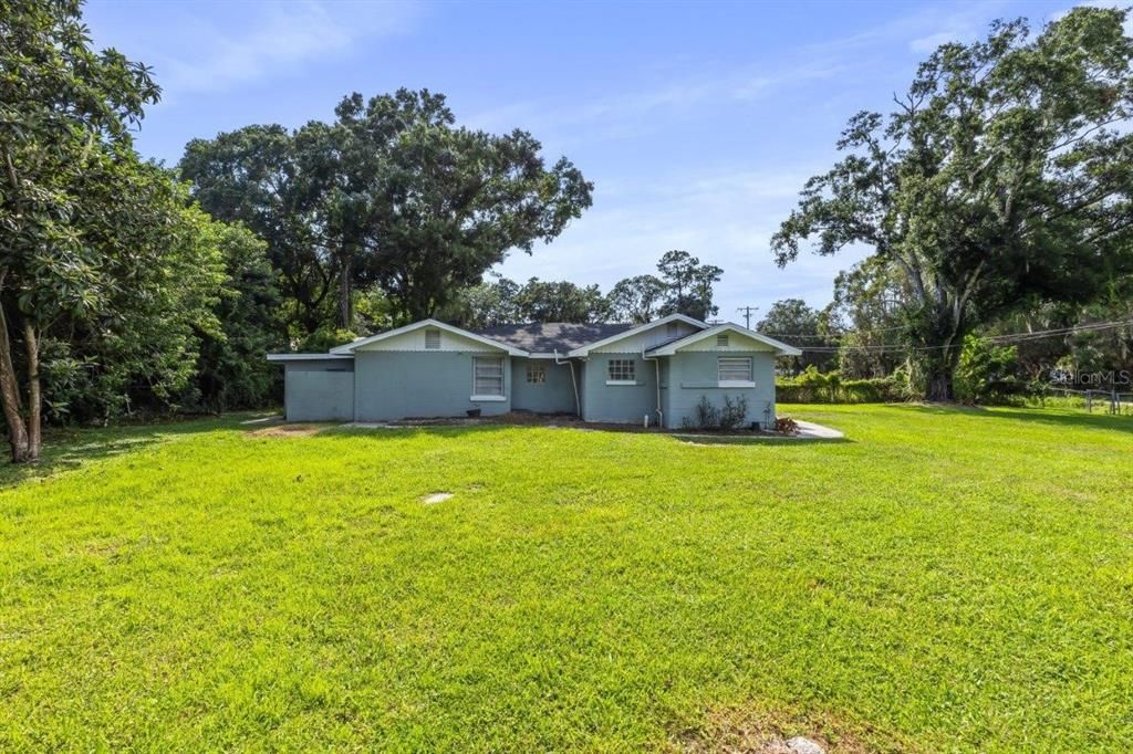 Side elevation and a view of the large fenced in lot that surrounds the home.