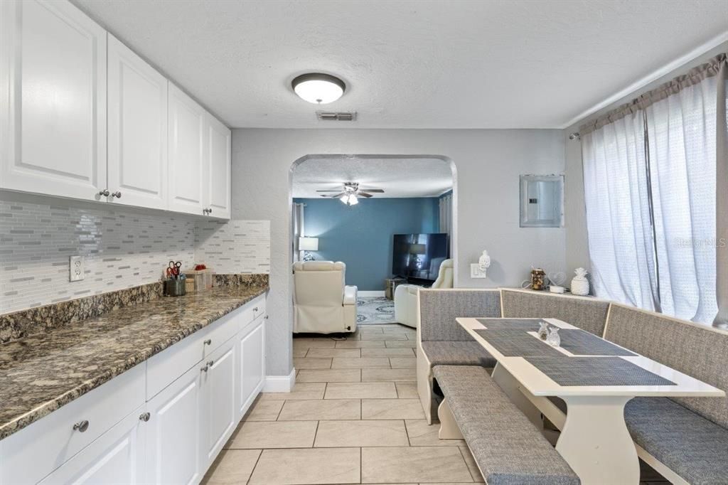 Galley-Style kitchen featuring granite countertops, ample cabinetry, stainless steel appliances, and a dinette.