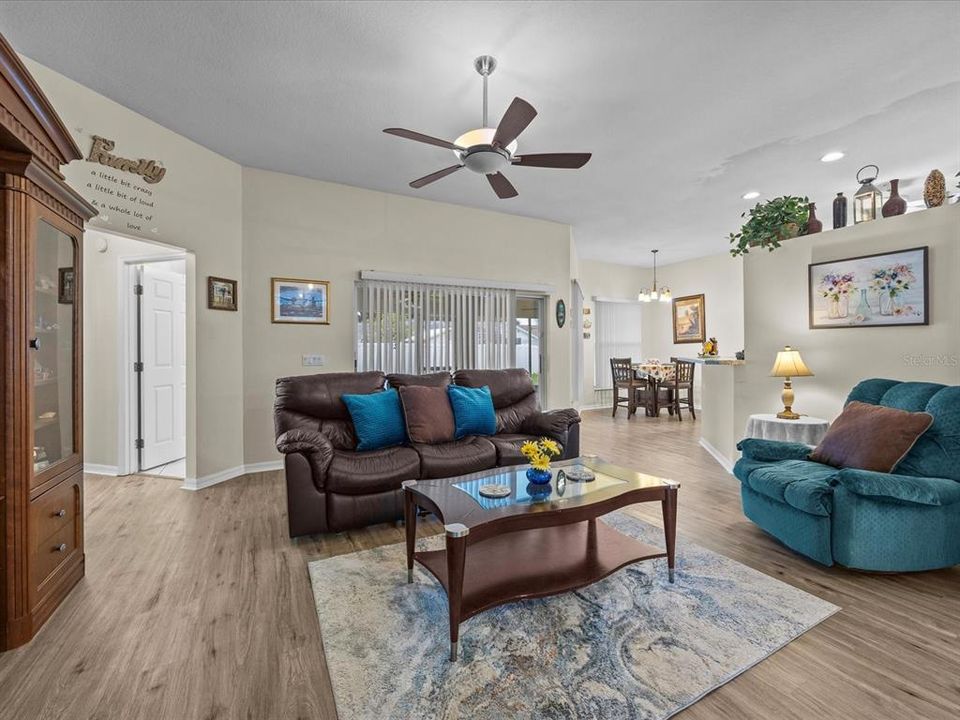 View from the foyer of the spacious living room, hall bathroom door, and breakfast room that faces the eat in kitchen.