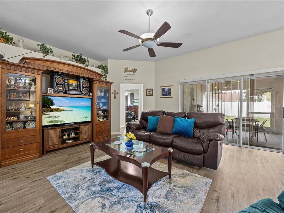 View from formal dining room towards the living room, the back hall takes you to 2 bedrooms and full bath. The 3 door sliding door gives you access to the large screened back porch.