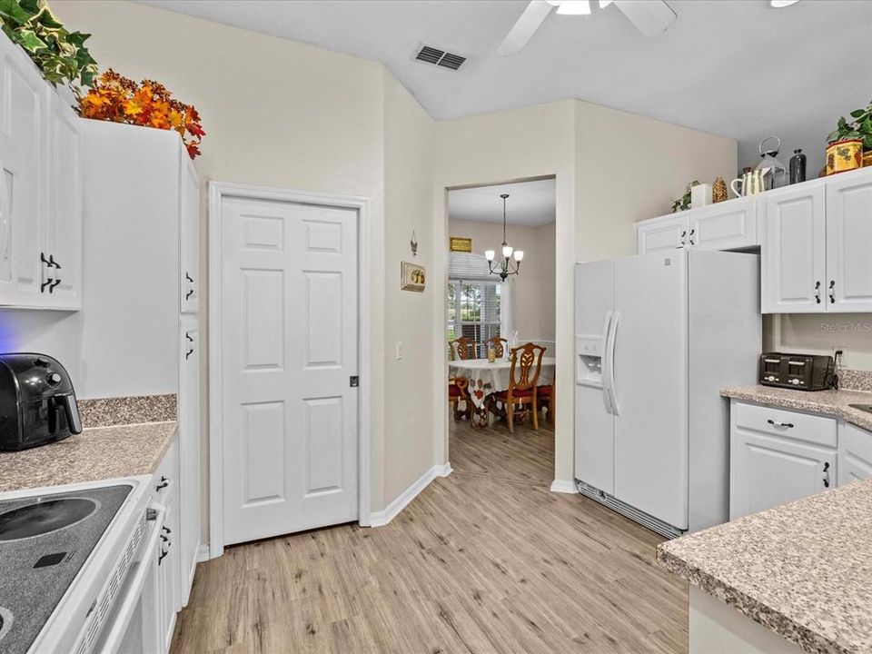 View from the breakfast room towards the kitchen, laundry room pocket door, and formal dining room.