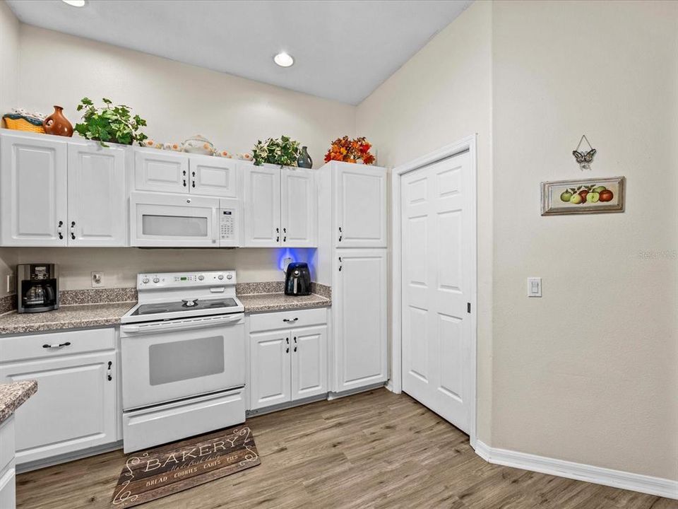 Kitchen pantry cabinetry and laundry room door access.