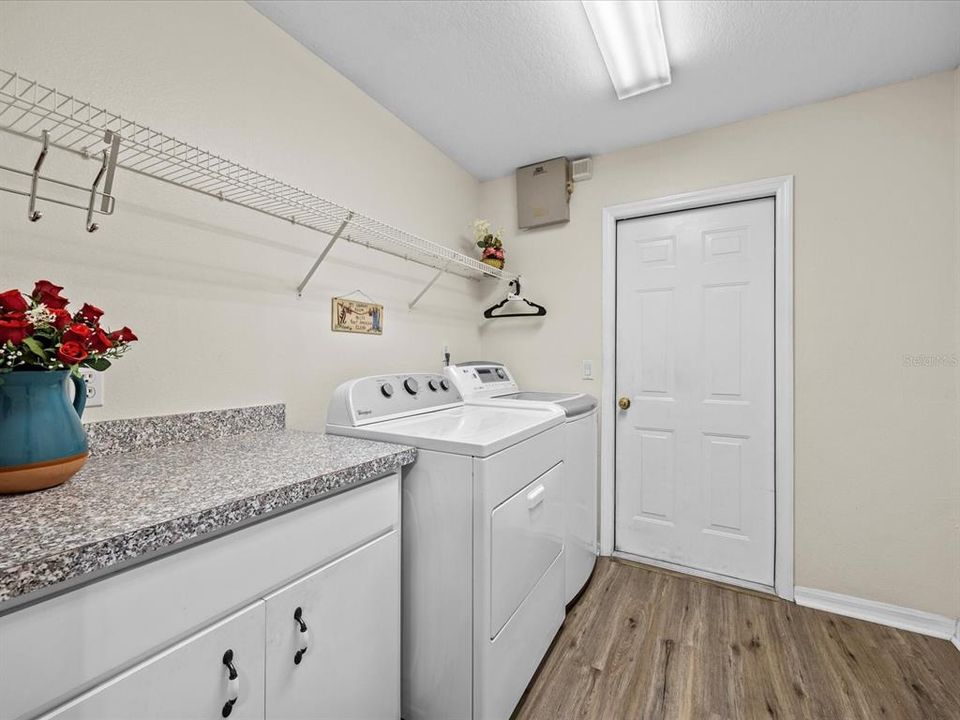 Large laundry room access from kitchen.  Washer and Dryer do not convey. Door access to 2 car garage. There is a stow away in-wall ironing board.