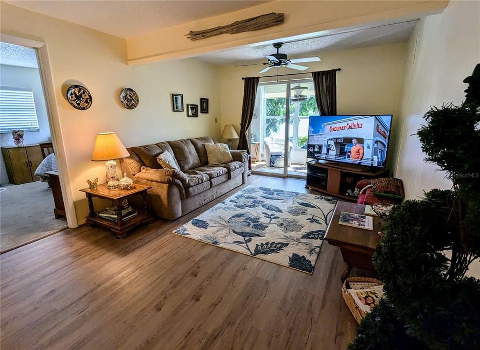 Living room and lanai beyond; primary bedroom on left