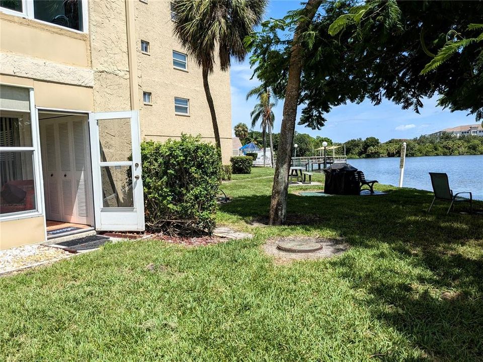 Just visible - covered gas grill/table for cooking out, the pier with glider seats and heated pool...