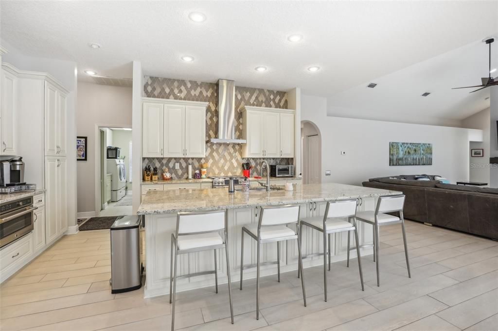 Kitchen with gas cook top and double ovens and a huge eat at kitchen island with sink