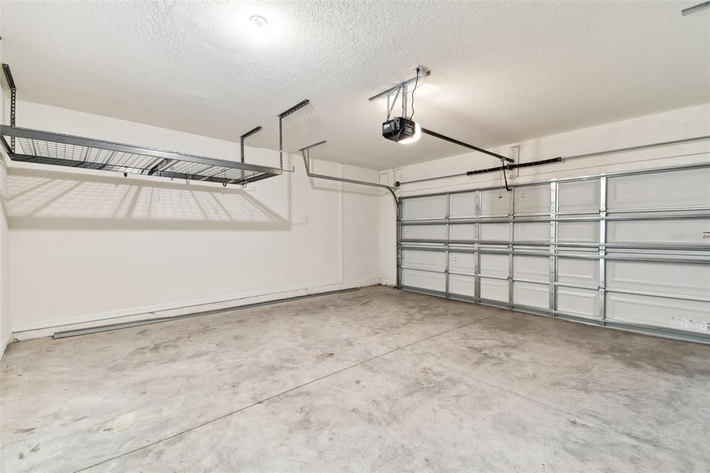 Garage featuring suspended extra storage shelving.