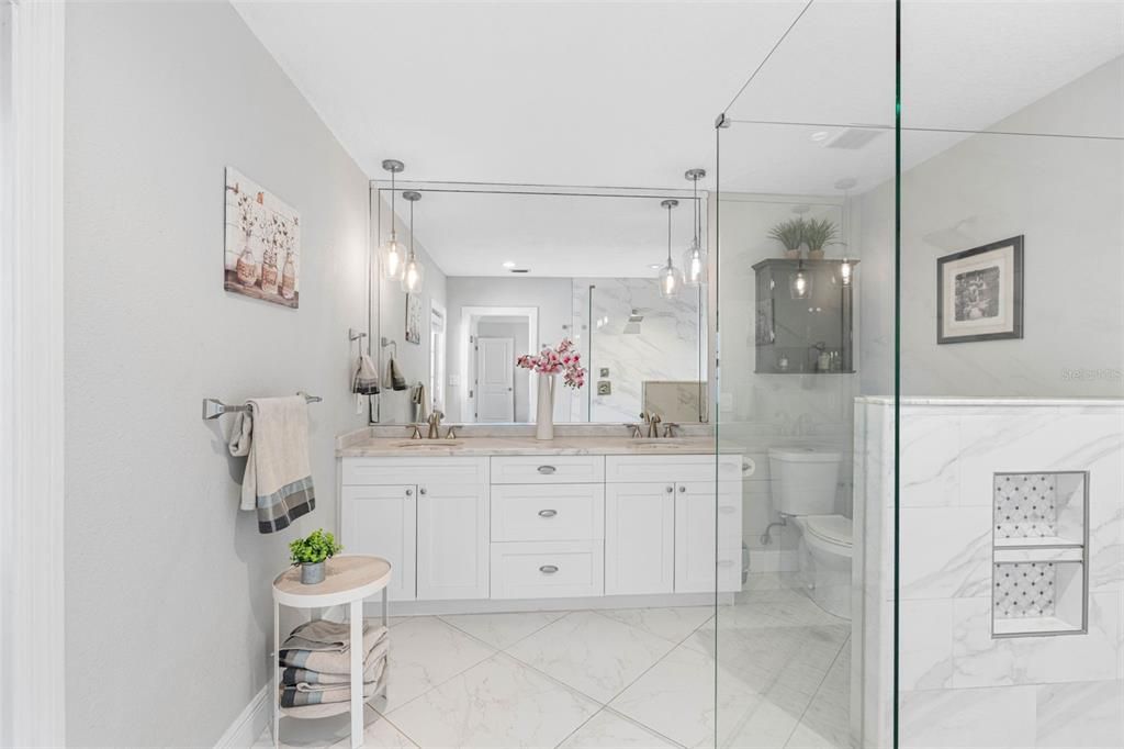 Spacious bathroom with marble and granite finishes and ample storage.