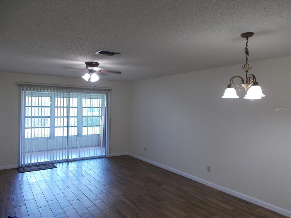 Living/dining room combo with the lanai in the background separated by a sliding door.