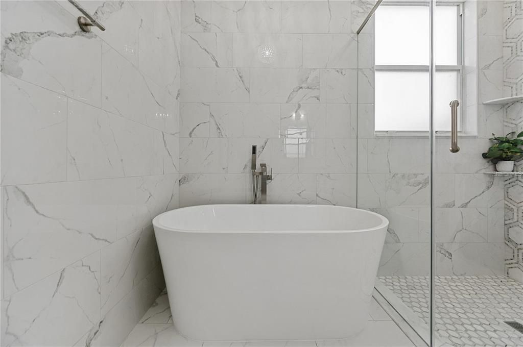 Beautiful free standing tub and corner shower; Light and bright with marble-like porcelain tiles