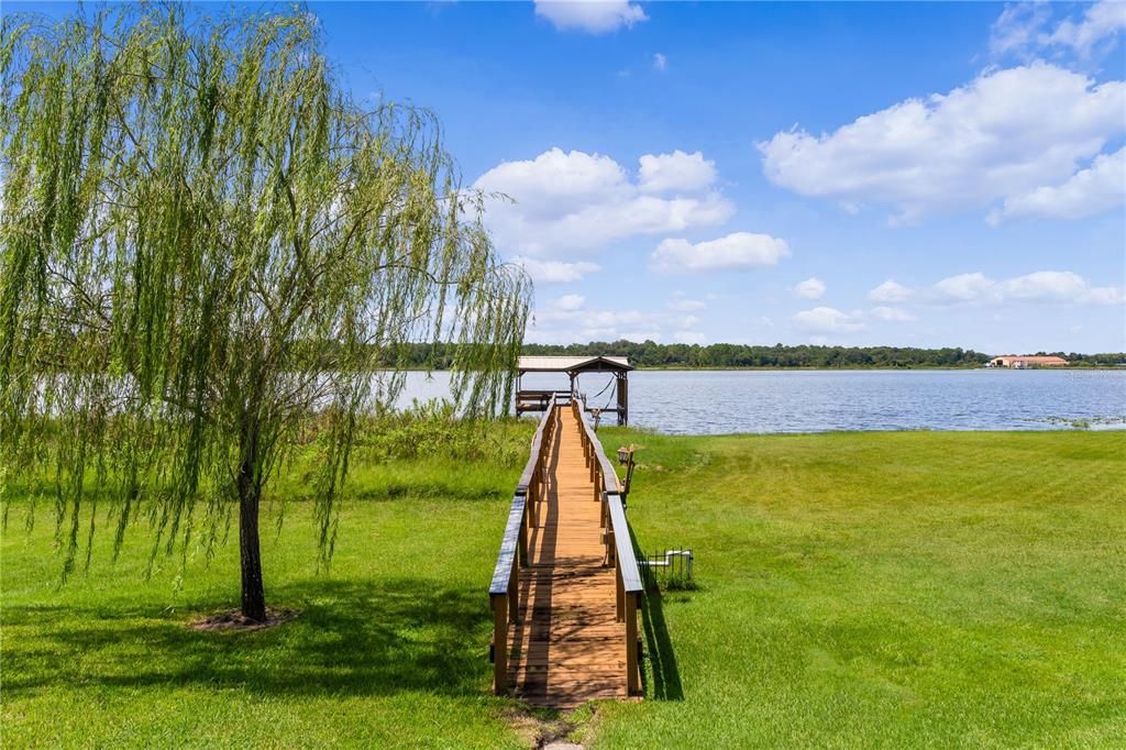 This property features a private boat dock complete with a boat lift and charming boathouse, offering convenient access to the water. It's the perfect setup for boating enthusiasts, providing easy storage and launching for your boat, while also creating a peaceful spot to relax and enjoy serene lake views. Ideal for making the most of waterfront living!