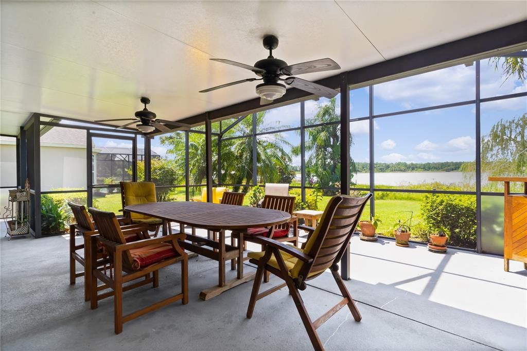 This spacious, screened-in back patio is the perfect spot to unwind, featuring two ceiling fans for comfort and offering stunning views of the lake and private boat dock. Whether you're enjoying a morning coffee or an evening breeze, this peaceful outdoor space is ideal for soaking in the serene waterfront setting.