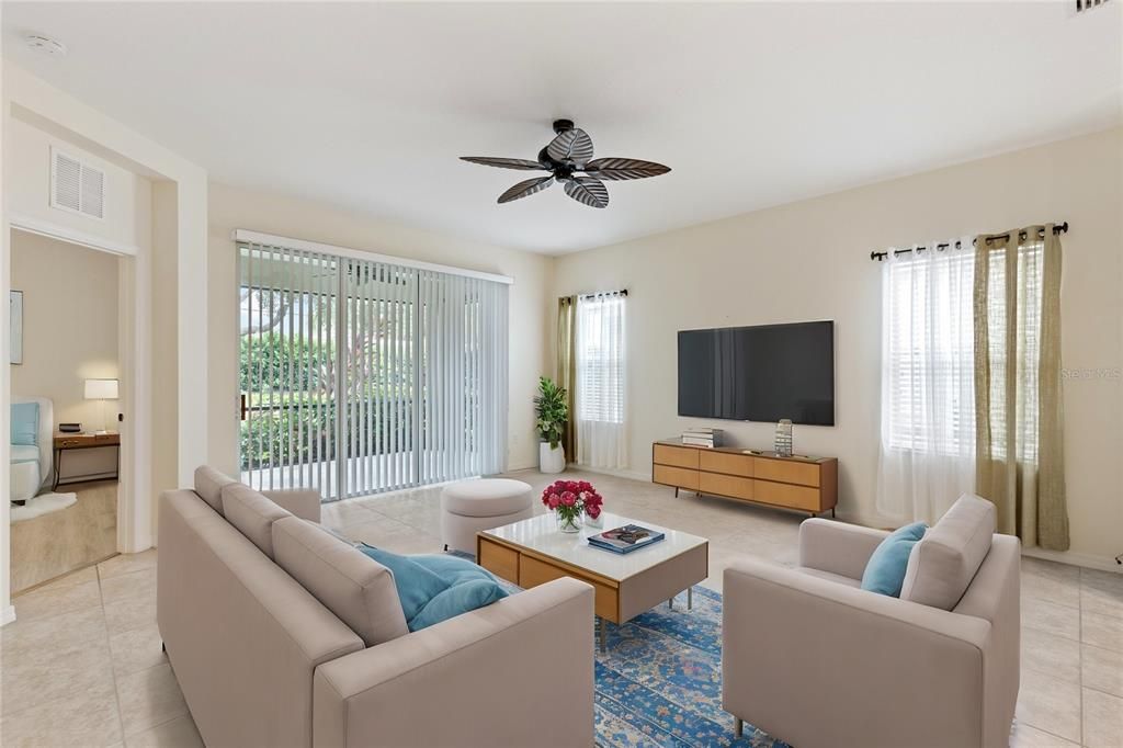 Spacious living room with 10' ceilings, ceramic tile, and a 3 panel sliding glass door leading out to the covered lanai.