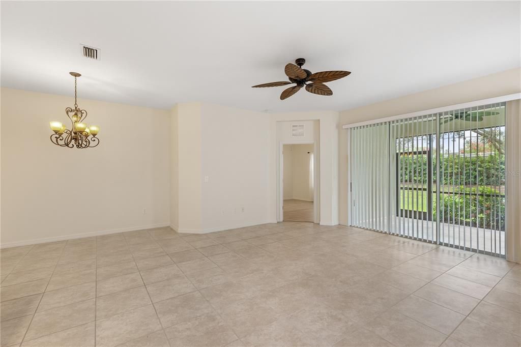 Spacious living room with 10' ceilings, ceramic tile, and a 3 panel sliding glass door leading out to the covered lanai.