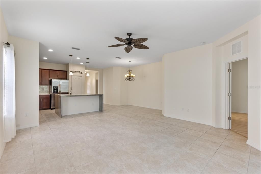 Spacious living room with 10' ceilings, ceramic tile, and a 3 panel sliding glass door leading out to the covered lanai.