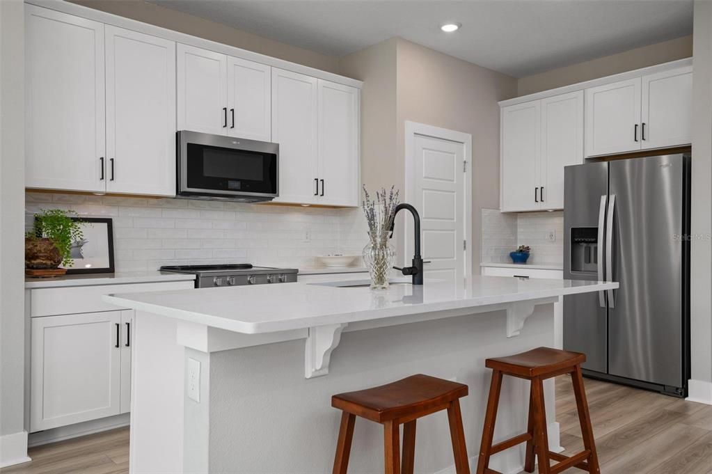 Kitchen With Wood Cabinets and Quartz Counters